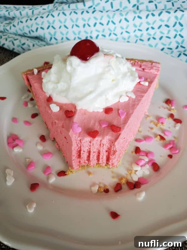 Slice of Kool Aid Pie with sprinkles, whipped cream, and a maraschino cherry