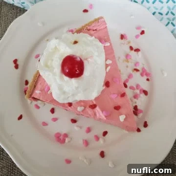 Slice of pink Kool Aid Pie on a white plate with heart sprinkles