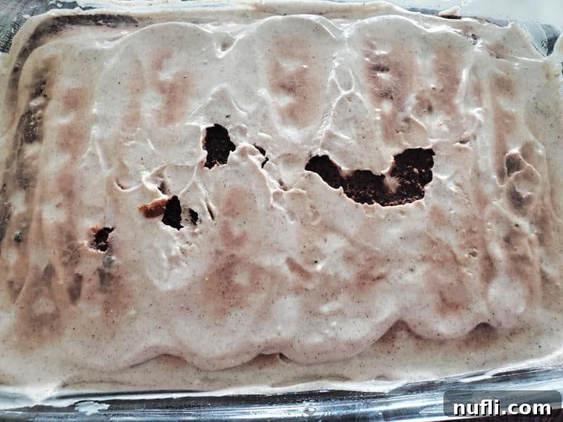 Cool Whip-covered cake in a glass baking dish, waiting for the final Oreo topping.