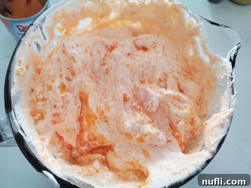 glass bowl with mandarin orange jello salad mix in it