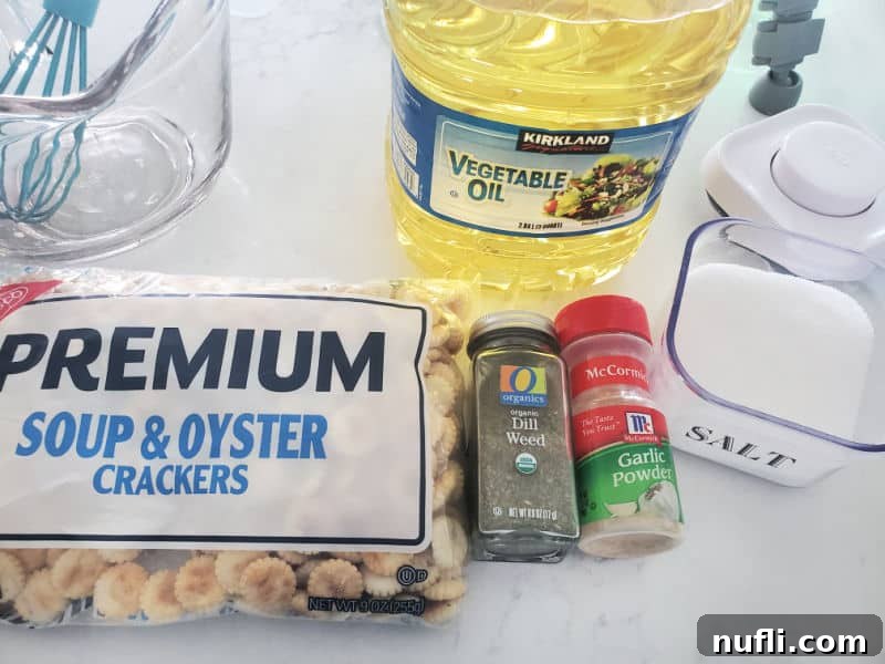Ingredients for Dill Oyster Crackers: oyster crackers, dried dill weed, garlic powder, salt, and vegetable oil laid out on a clean surface.