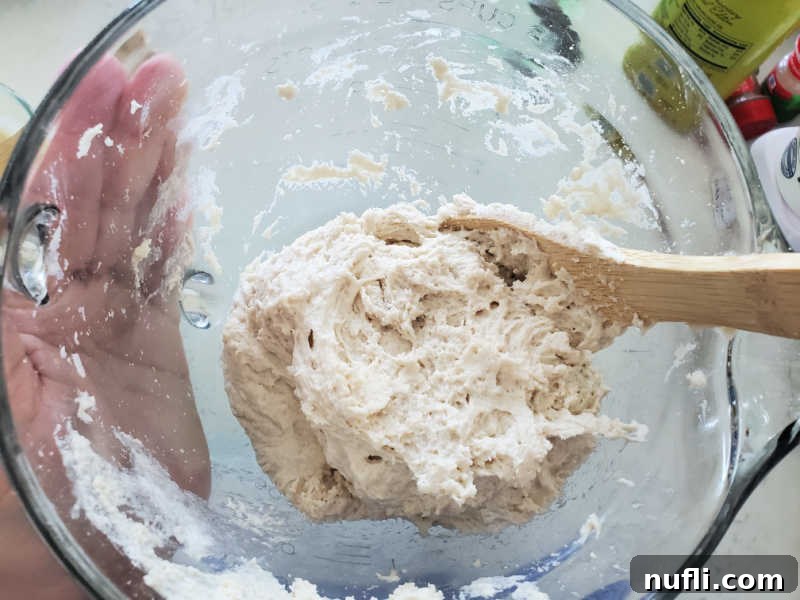 Bisquick dough ball in a glass bowl with a wooden spoon