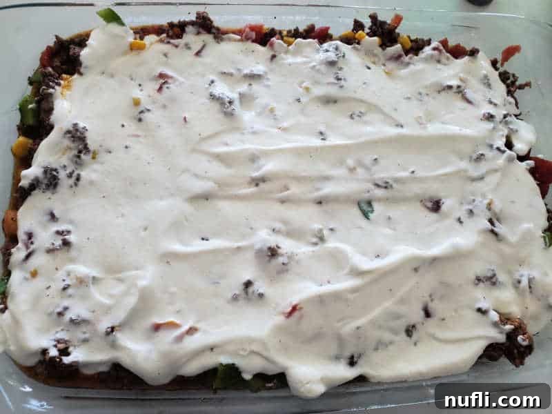 sour cream mixture over ground beef and vegetables in a casserole dish