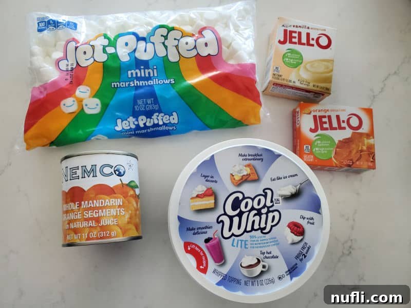 Bag of jet puffed mini marshmallows, box of vanilla pudding, jello orange, mandarin oranges in a can, and cool whip
