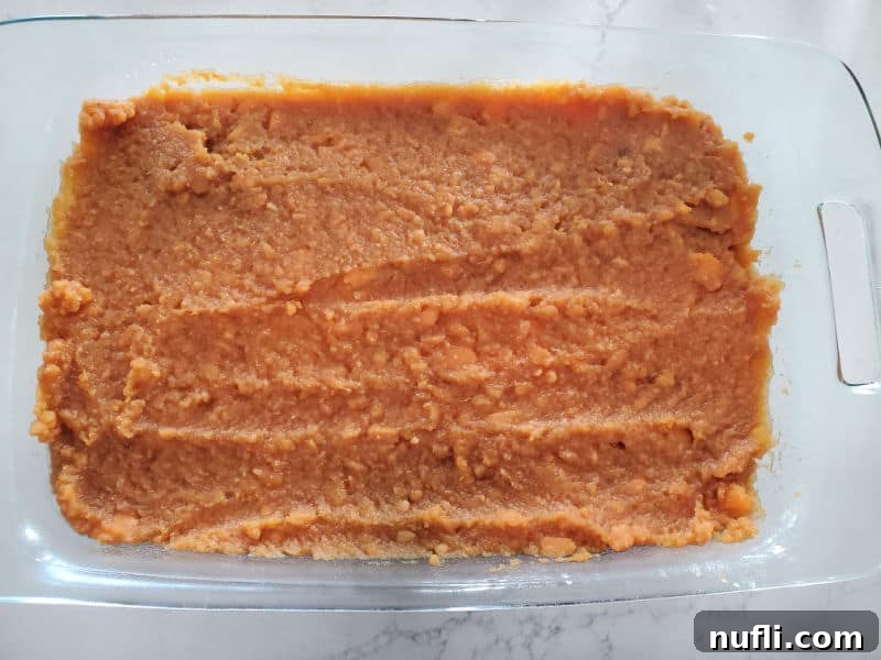mashed sweet potatoes spread in a glass casserole dish