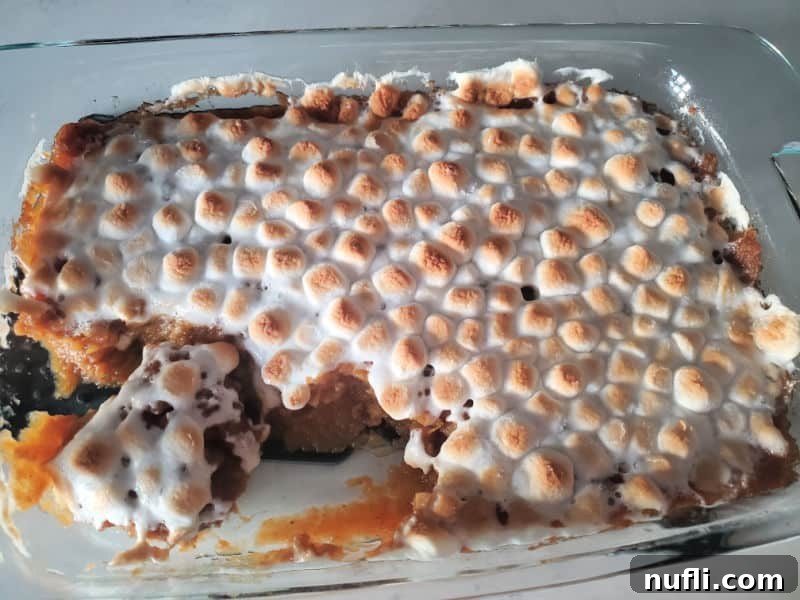 sweet potato casserole with mini marshmallows in a glass casserole baking dish
