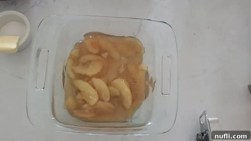 Easy Bisquick Apple Cobbler 5 Apple pie filling in a glass baking dish next to a bowl with sugar and butter