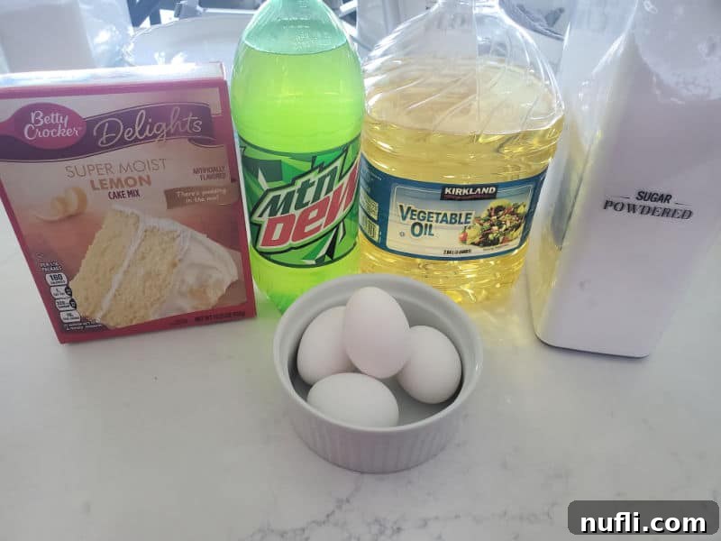 A collection of essential ingredients for a delicious Mountain Dew cake: a box of lemon cake mix, a bottle of Mountain Dew soda, vegetable oil, powdered sugar, and a bowl of fresh eggs, all arranged on a kitchen counter.