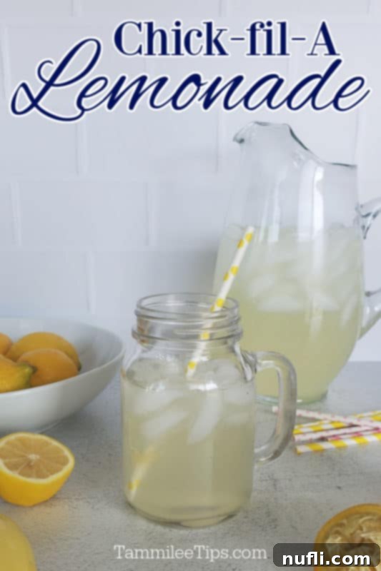 Chick fil A lemonade over a pitcher and mason jar filled with lemonade. Sitting next to a bowl of lemons and cut lemons. 