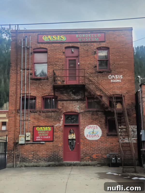 Oasis Bordello museum sign on a brick building with a stairs up the back 