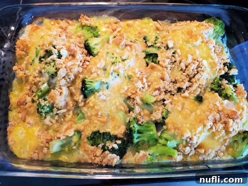 A baked Cracker Barrel Broccoli Cheddar Chicken casserole in a glass baking dish, showing golden Ritz crackers, melted cheese, and tender broccoli.