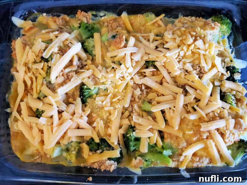 A generous sprinkling of shredded cheddar cheese over the hot, baked broccoli and Ritz cracker topping in the baking dish, melting beautifully.