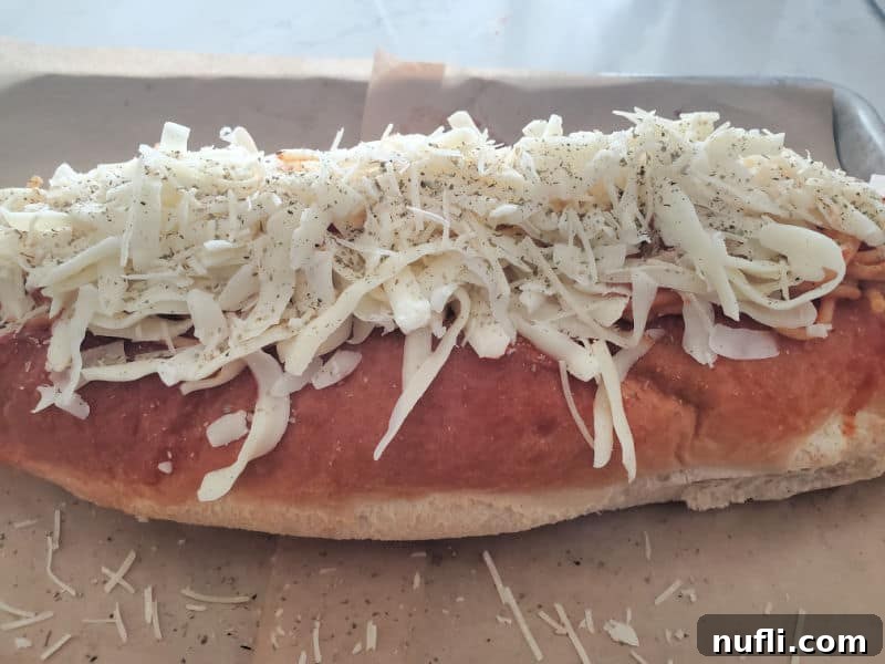 Ultimate Spaghetti Stuffed Garlic Bread 5 Mozzarella cheese and seasoning on top of a loaf of bread