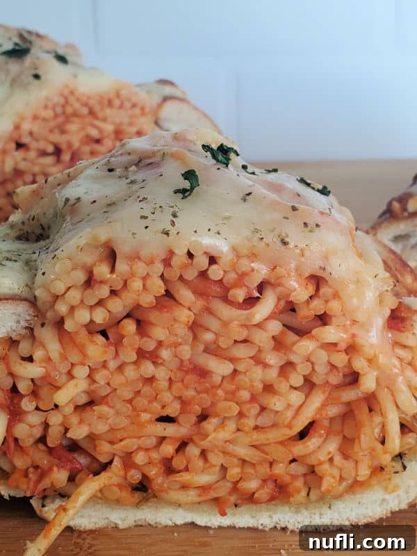 Ultimate Spaghetti Stuffed Garlic Bread 7 Spaghetti Stuffed Garlic Bread on a wood cutting board