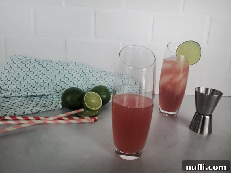 The second step of making a Bay Breeze cocktail: adding pineapple juice into a highball glass, with a cocktail jigger nearby.
