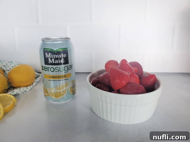 A can of Minute Maid Zero Sugar Lemonade sits beside a vibrant bowl of fresh, ripe strawberries, symbolizing the simple yet essential ingredients for a delicious Freckled Lemonade.