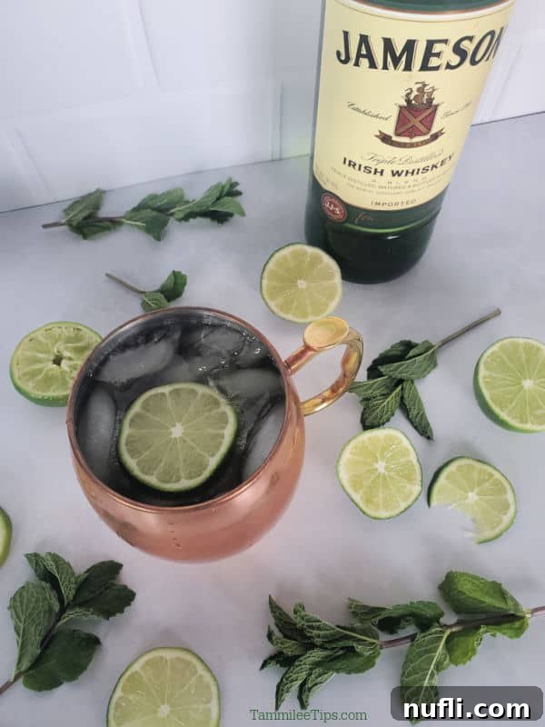 Irish Mule Cocktail and Mocktail Recipe Video 5 Irish Mule in a Copper Mug next to a bottle of Jameson Whisky and lime wheels and mint sprigs