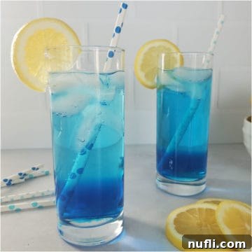 Shake Up the Sex in the Driveway: Video Cocktail Recipe 11 Two blue cocktails with lemon wheels and paper straws