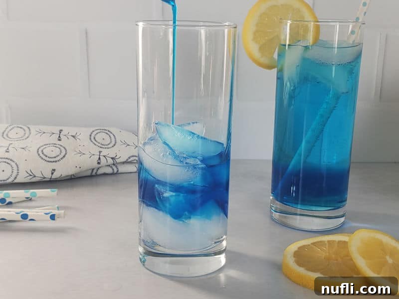 Shake Up the Sex in the Driveway: Video Cocktail Recipe 5 Blue Curacao being poured into a tall glass with ice and Peach Schnapps, next to a completed blue cocktail garnished with a lemon wheel.