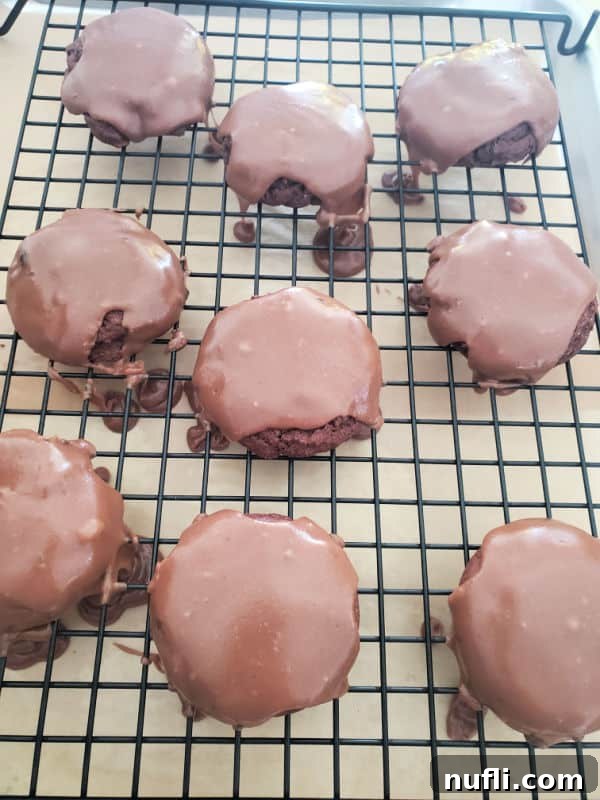 Decadent Texas Sheet Cake Cookies 6 Texas sheet cake cookies with chocolate icing over the top of them on a drying rack, close-up view