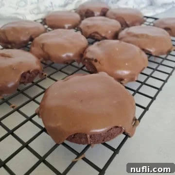 Decadent Texas Sheet Cake Cookies 9 Texas sheet cake cookies on a metal cooling rack, perfectly iced