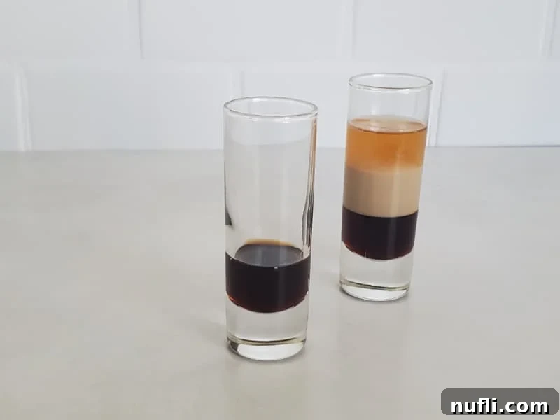 Crafting the B52 Shot A Video Guide 5 A shot glass with a base layer of Kahlua, next to a finished B52 layered shot.