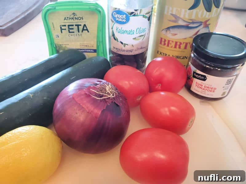 A vibrant display of fresh Greek salad ingredients on a wooden cutting board, including feta, Kalamata olives, olive oil, lemon, red onions, and Roma tomatoes, ready for preparation.