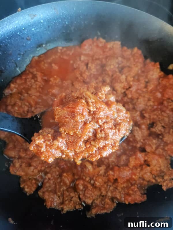 spoon holding ground beef mixture over a skillet