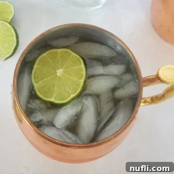 Mexican Mule with a lime circle in a copper mule mug next to more lime circles