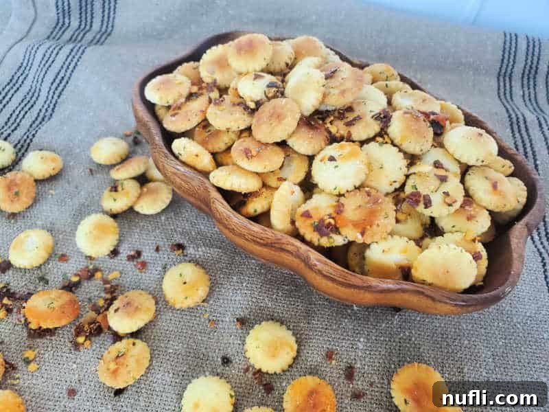 Spicy Seasoned Oyster Crackers 4 Close-up of baked spicy oyster crackers in a wooden bowl on a burlap cloth, highlighting their crispy texture