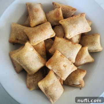 Air Fryer Pizza Rolls on a white plate, served with dipping sauce.