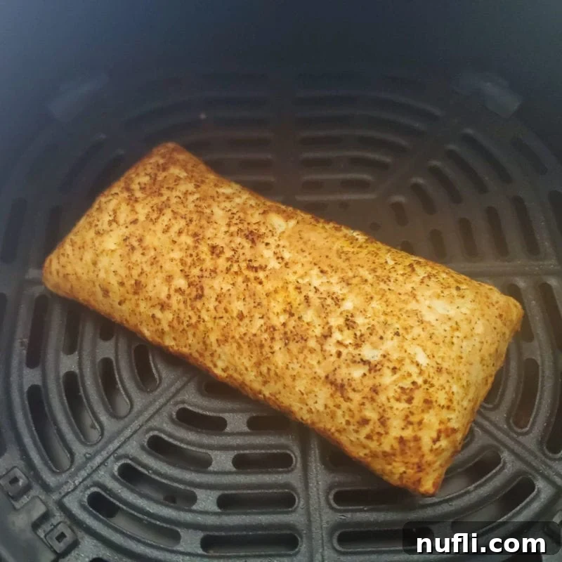 Air Fryer Hot Pocket Perfection 4 A freshly air-fried Hot Pocket, perfectly golden and crispy, resting in an air fryer basket after cooking.