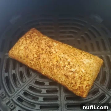 Crispy Air Fryer Hot Pockets 5 A perfectly air-fried Hot Pocket, golden and crispy, resting in an air fryer basket