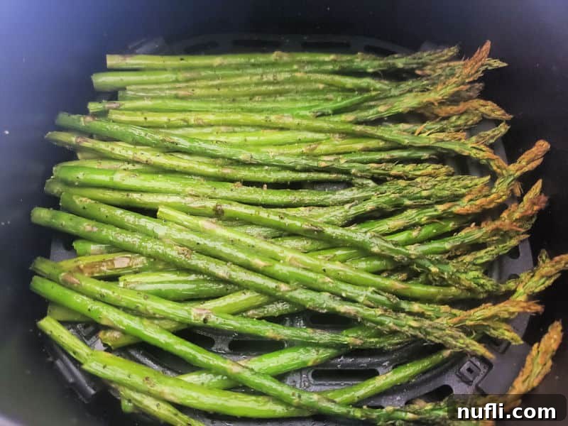 Air-Fried Asparagus 4 Crispy air fried asparagus spears still in the air fryer basket, showing their golden brown tips