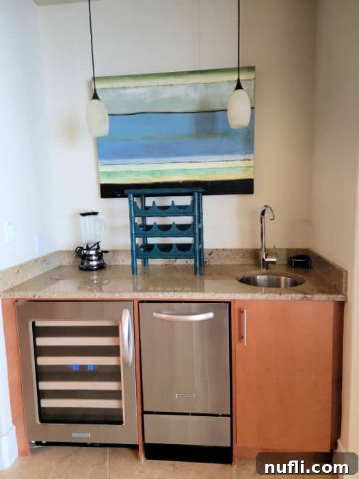 Turquoise Place: Orange Beach Alabama's Luxury Gulf Resort 8 art hanging above a small counter area with wine fridge, ice maker, and sink