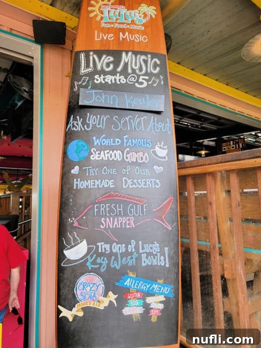Lulu's wooden surfboard sign displaying music and food specials