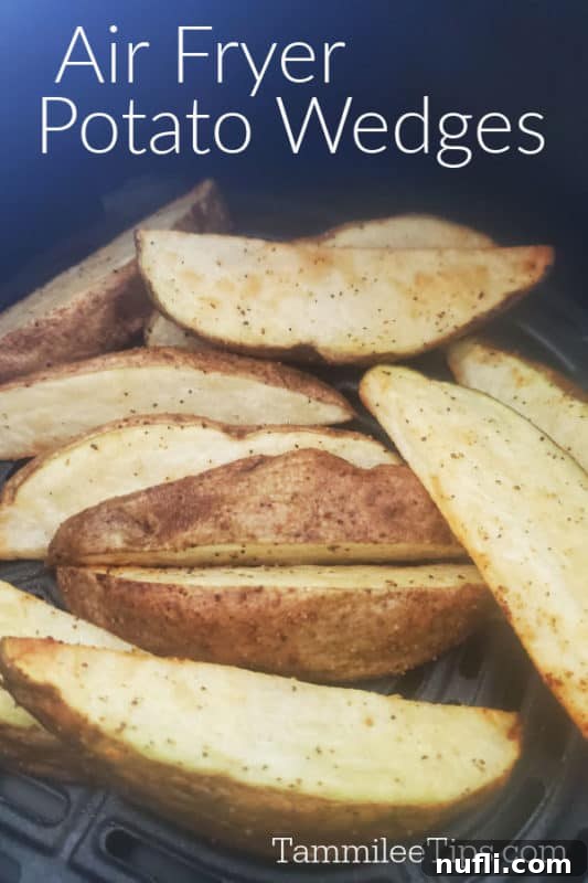 Crispy golden brown air fryer potato wedges piled high in an air fryer basket, seasoned to perfection.