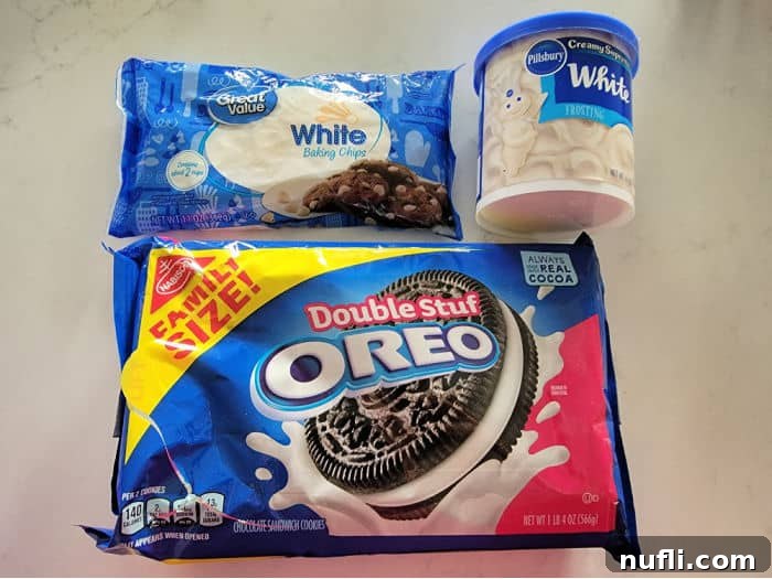 Easy 3-Ingredient Oreo Fudge 3 The three essential ingredients for easy Oreo fudge: a package of Oreo cookies, a bag of white chocolate chips, and a tub of vanilla icing, neatly arranged on a kitchen counter.
