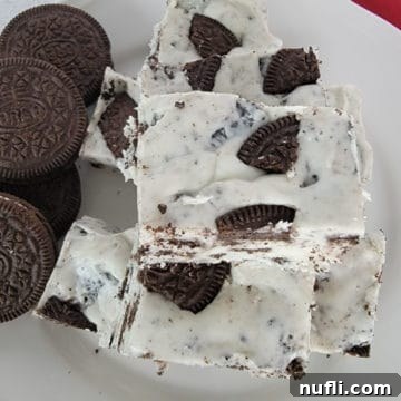 Easy 3-Ingredient Oreo Fudge 6 3-Ingredient Oreo Fudge stacked on a white plate next to Oreo Cookies