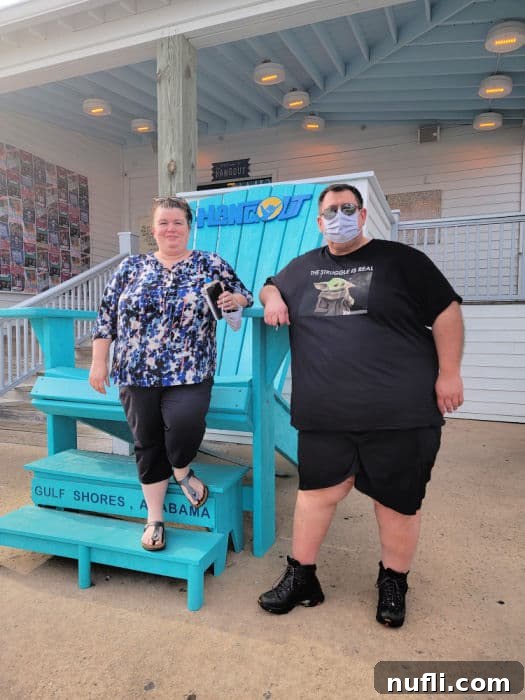 Tammilee and John next to the large blue Adirondack Chair at The Hangout