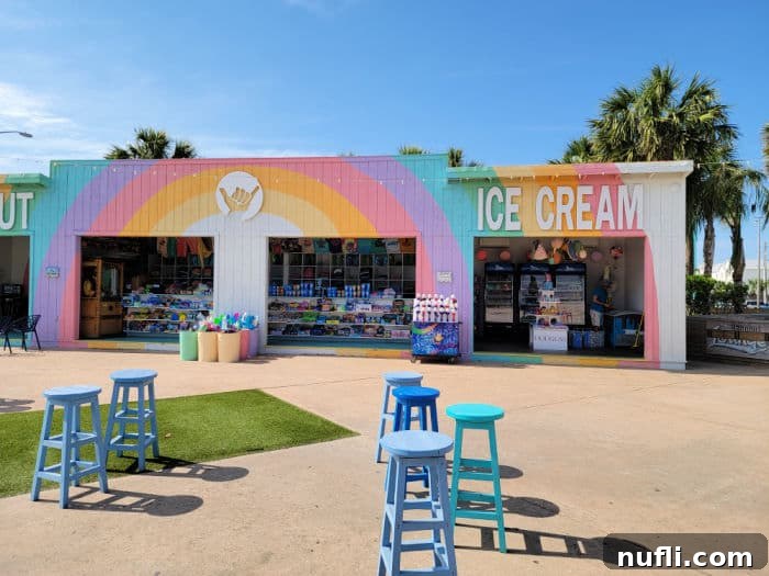 Rainbow colored building with an ice cream sign next to blue bar stools