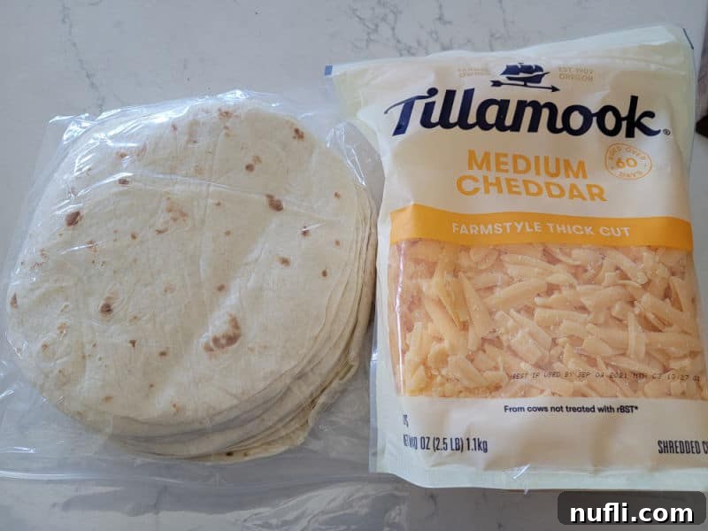 Crispy Air Fryer Quesadillas 3 stack of tortillas and a bag or Tillamook medium cheddar cheese on a white counter.