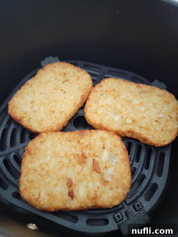 air fried hashbrown patties in an air fryer basket