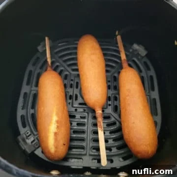 Crispy Air Fryer Frozen Corn Dogs 6 Three air fried corndogs in an air fryer basket