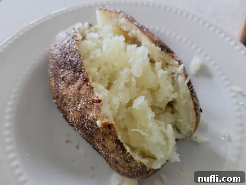 potato split open on a white plate