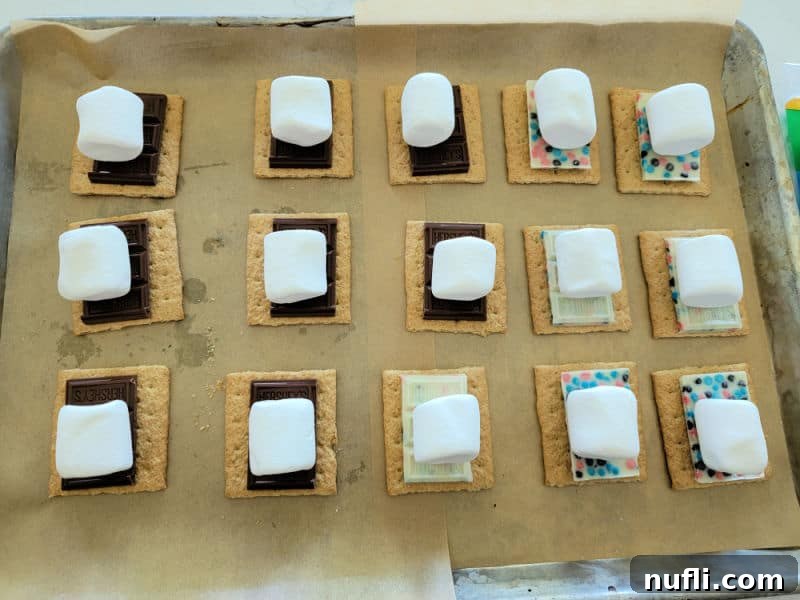 oven smores ingredients on a parchment lined baking sheet ready for the oven. 