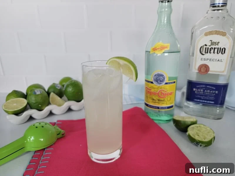 Ranch Water Cocktail in a highball glass on a red napkin with Jose Cuervo and Topo Chico and limes