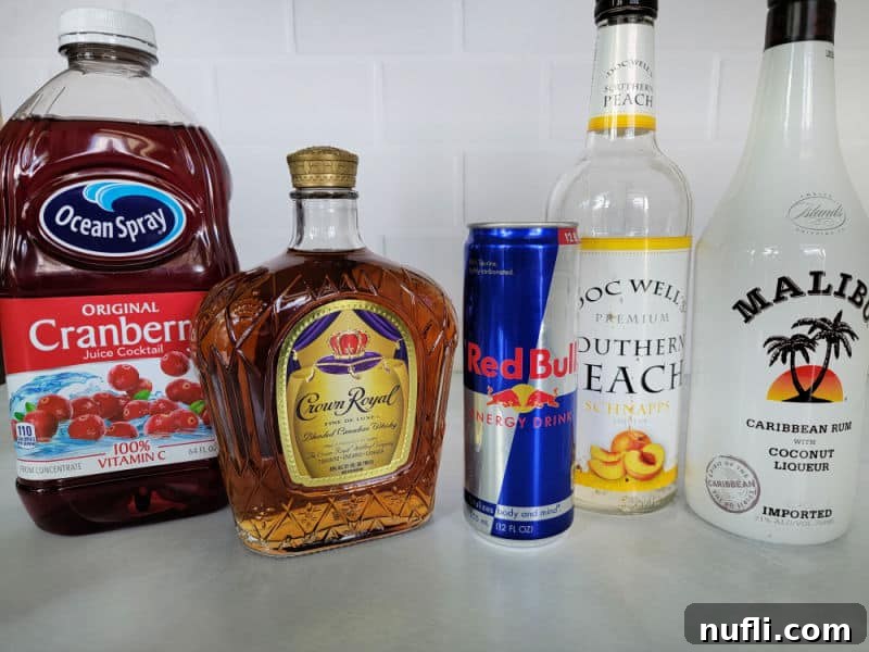 Cranberry juice, Crown Royal, Red Bull, Peach Schnapps, and a Malibu bottle on a counter