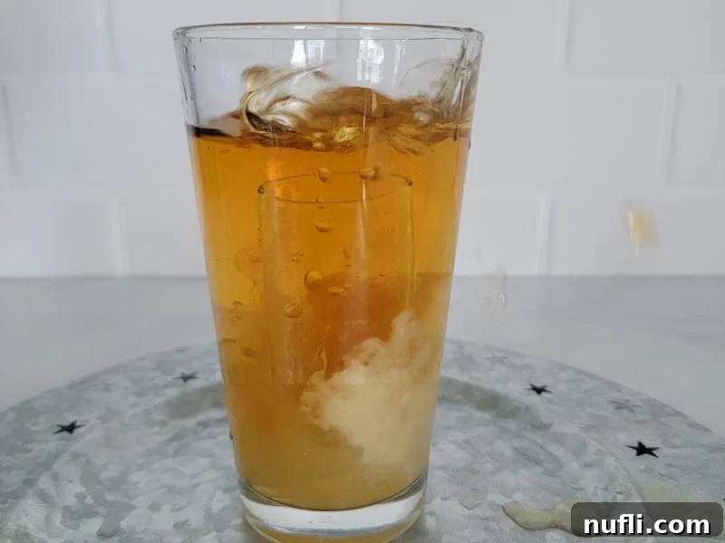 Glass with a shot glass just dropped into it with the liquid swirling. 