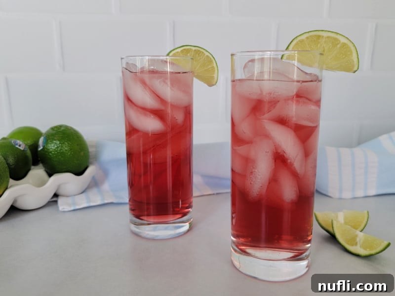 Effortless 3-Ingredient Woo Woo Cocktail 4 2 Woo Woo cocktails in tall glasses with lime wedge garnish next to a pile of limes